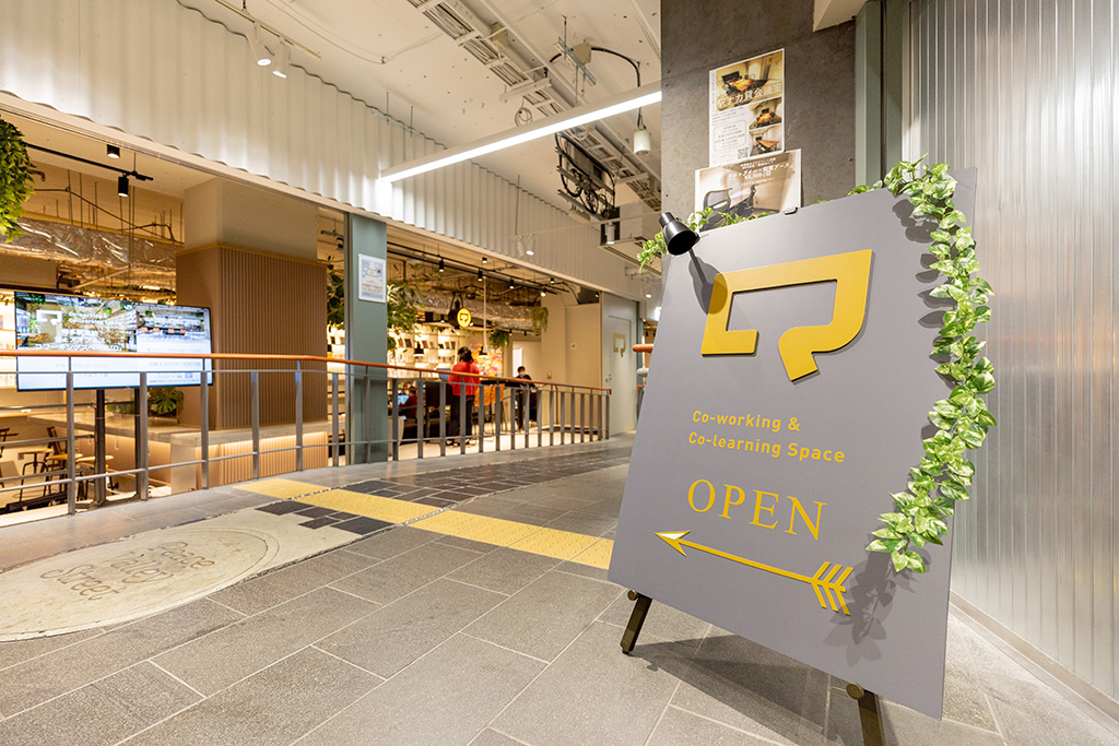 道順3：通路を進むと、左手にシェアオフィス「Q」のラウンジがあります（「Q」の看板が目印です）。